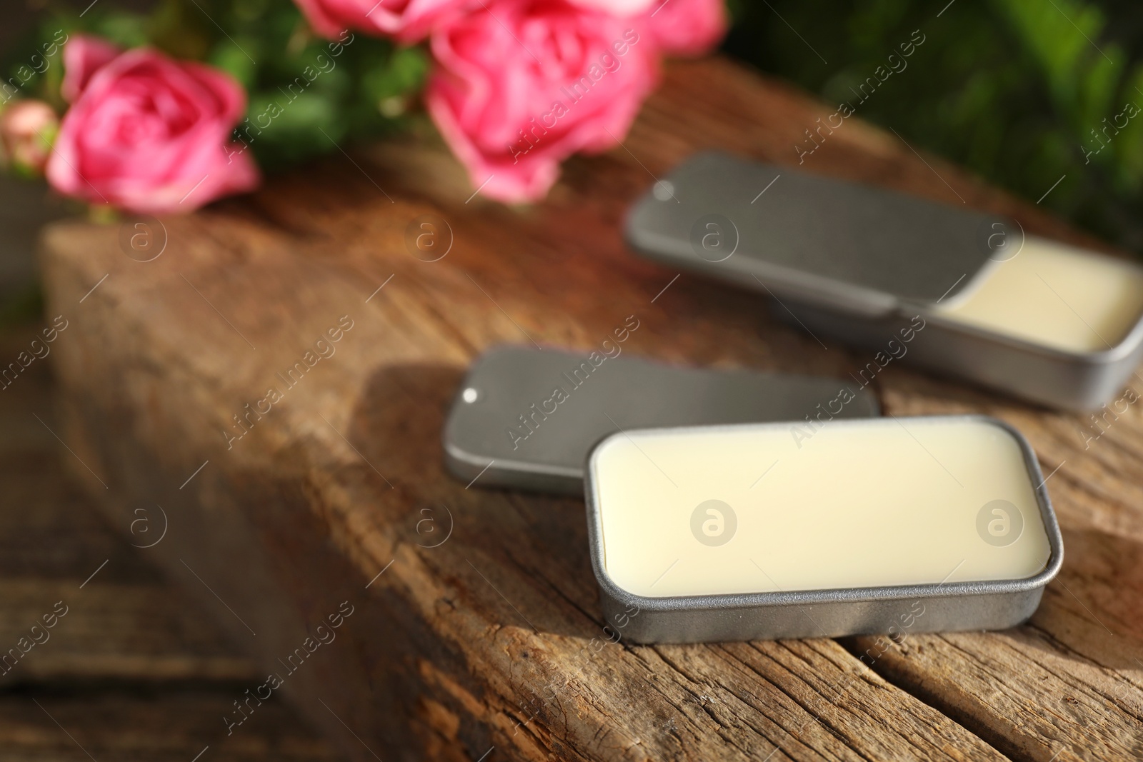 Photo of Natural solid perfume and roses on table, closeup