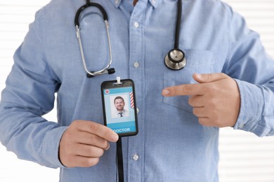 Photo of Doctor pointing at his badge in hospital, closeup