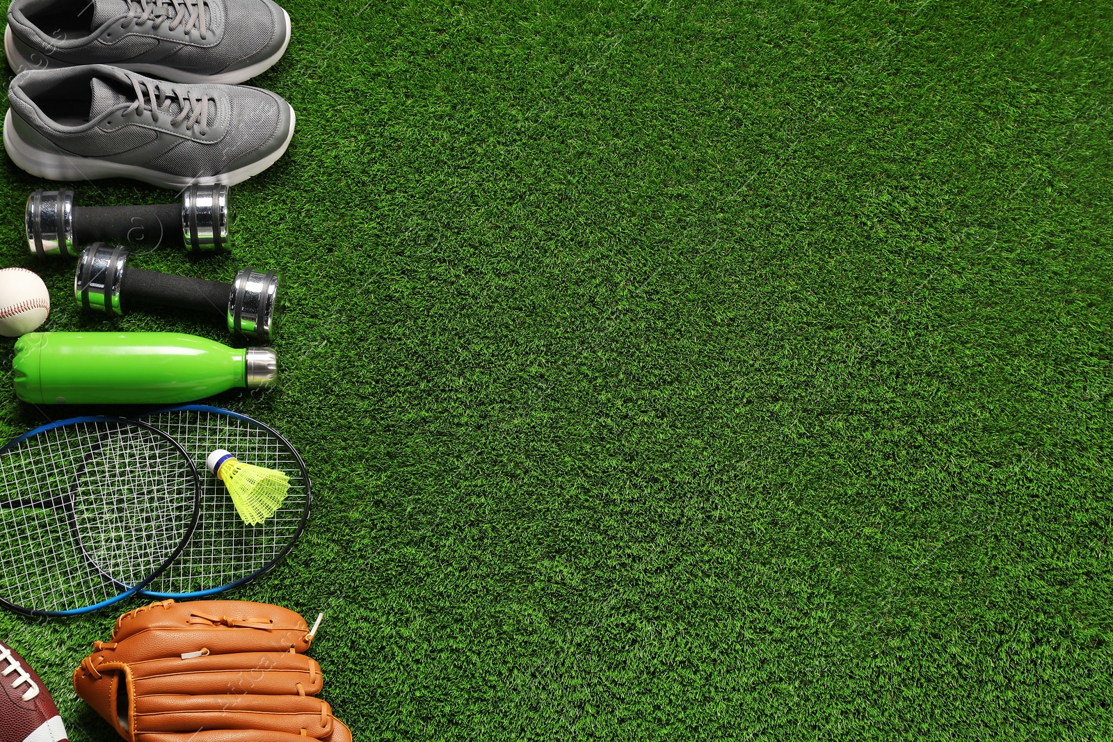 Photo of Different sports equipment on artificial grass, flat lay. Space for text