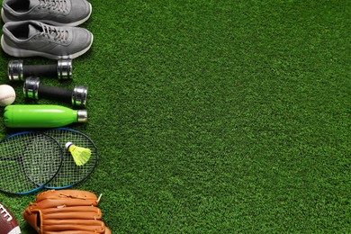 Photo of Different sports equipment on artificial grass, flat lay. Space for text