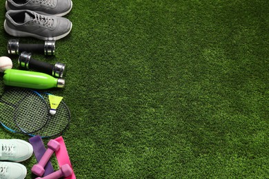 Photo of Different sports equipment on artificial grass, flat lay. Space for text