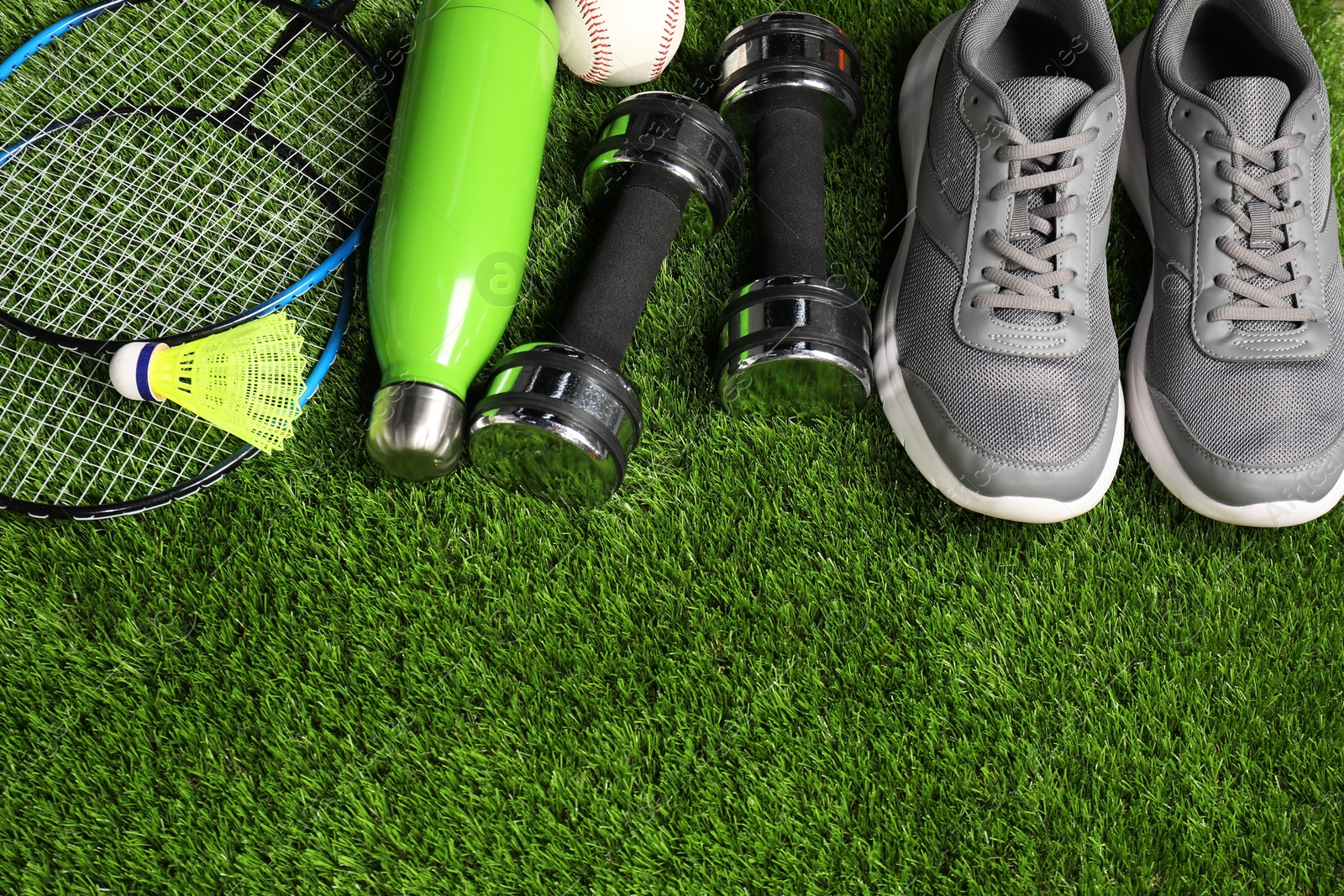 Photo of Different sports equipment on artificial grass, above view. Space for text