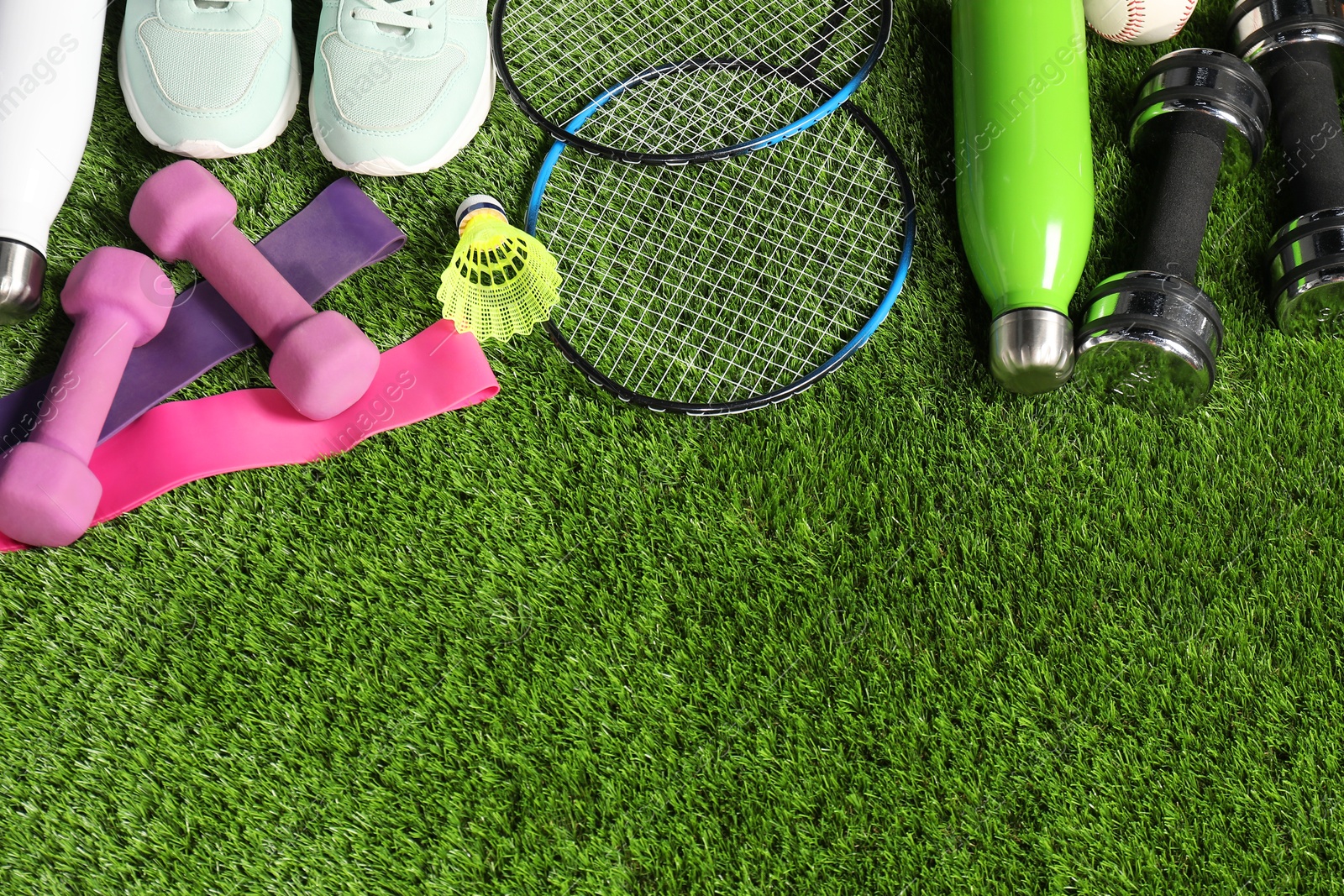 Photo of Different sports equipment on artificial grass, flat lay. Space for text