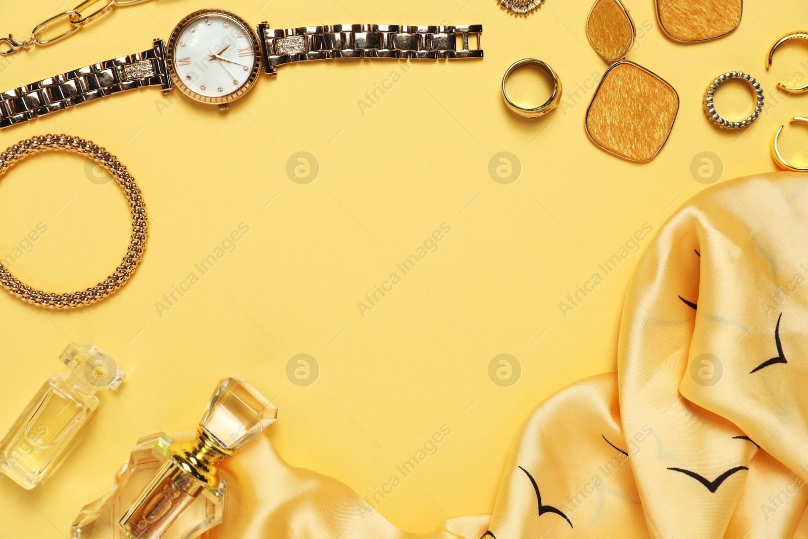 Photo of Many stylish jewelry, perfume and accessories on pale yellow background, flat lay. Space for text