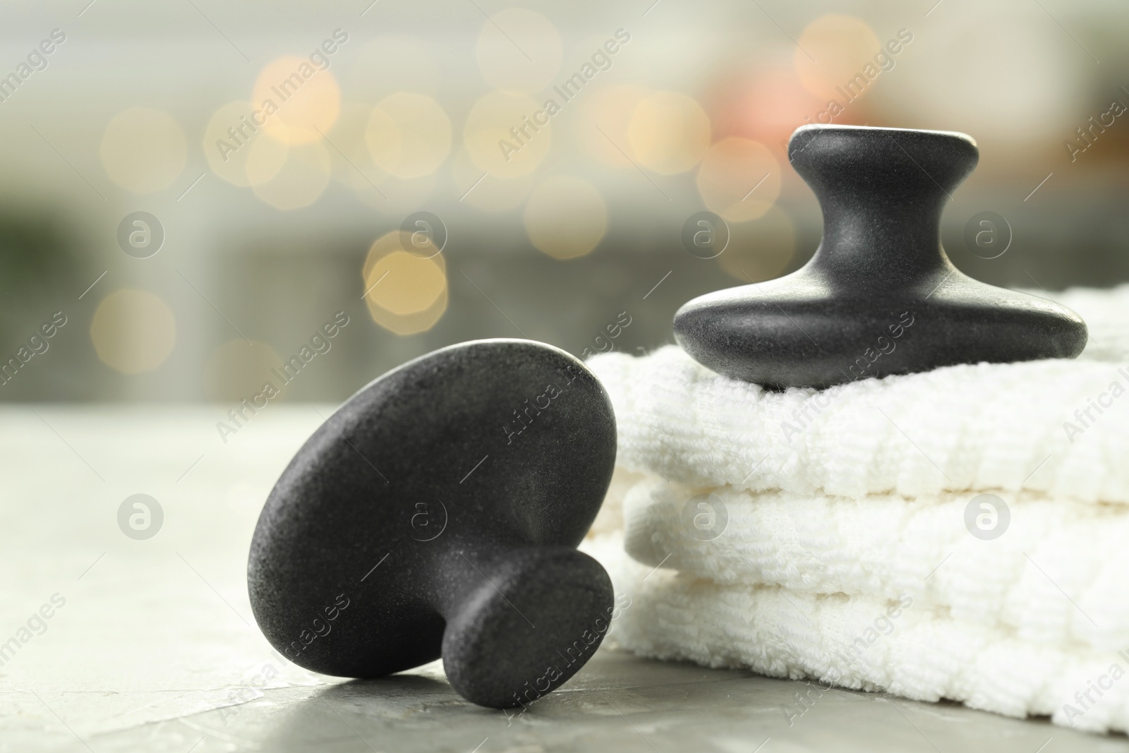 Photo of Spa stones and towels on grey background, closeup