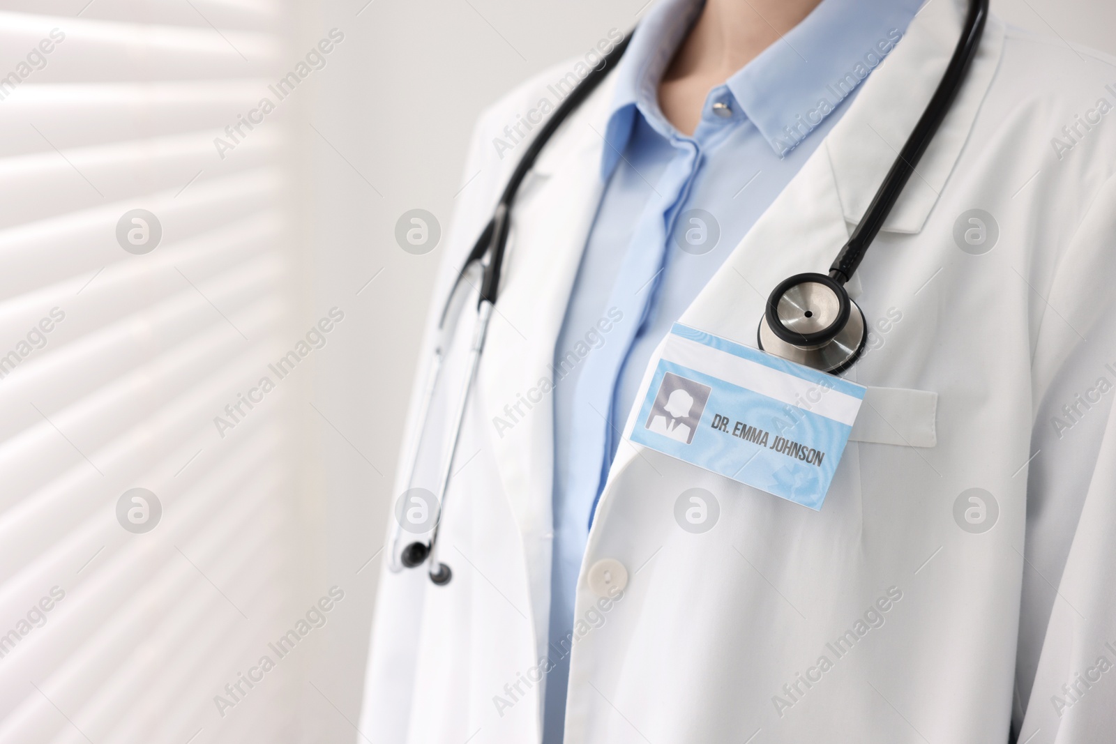 Photo of Doctor with badge in clinic, closeup. Space for text