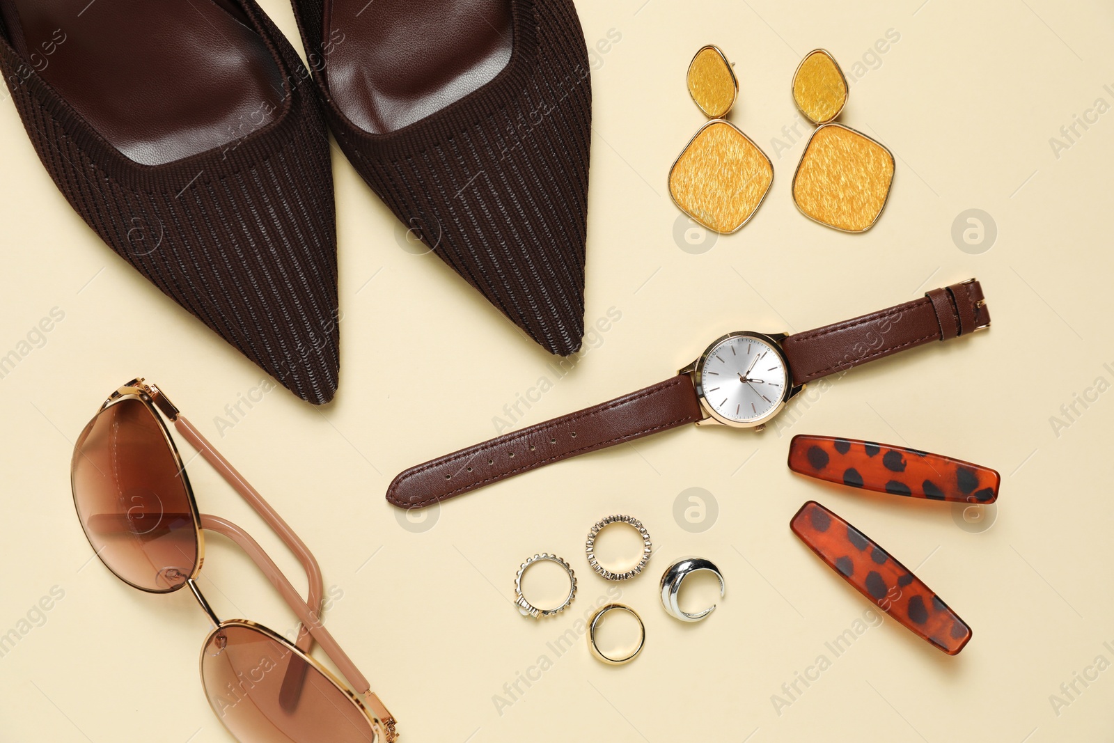 Photo of Flat lay composition with jewelry, accessories and shoes on beige background