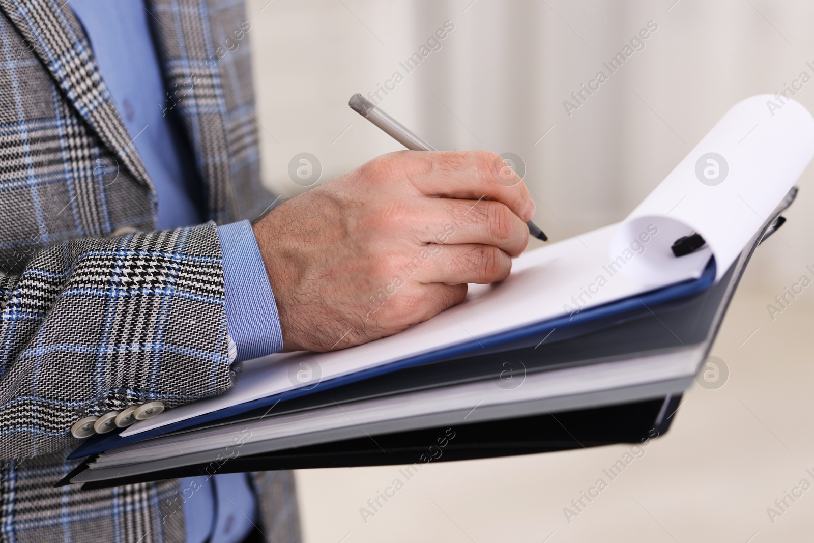 Photo of Real estate appraisal. Inspector with clipboard conducting property valuation indoors, closeup