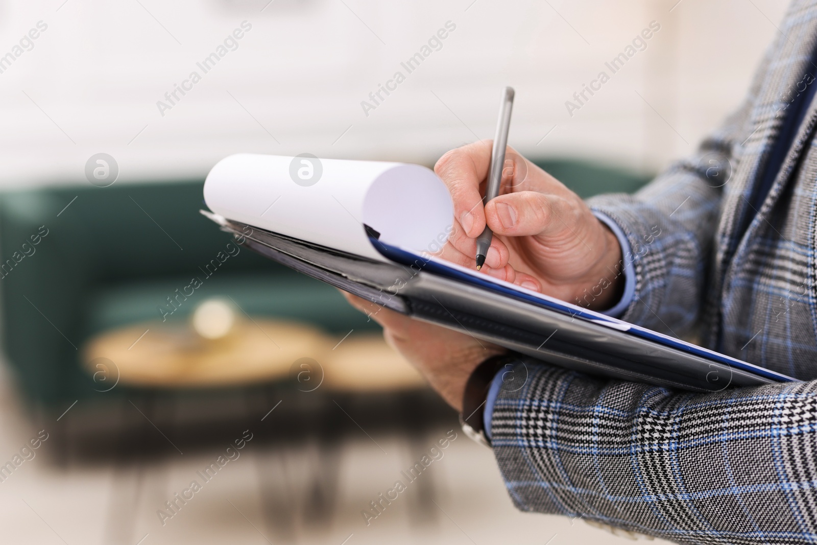 Photo of Real estate appraisal. Inspector with clipboard conducting property valuation indoors, closeup. Space for text