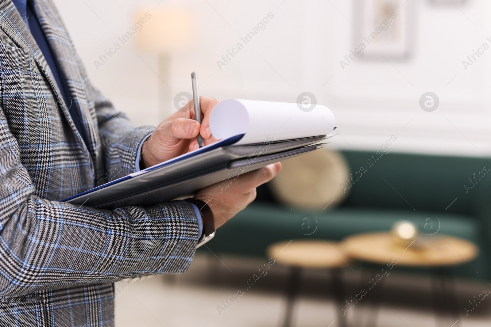 Photo of Real estate appraisal. Inspector with clipboard conducting property valuation indoors, closeup. Space for text