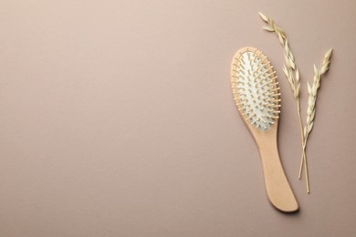 Photo of Wooden hair brush and spikes on color background, top view. Space for text