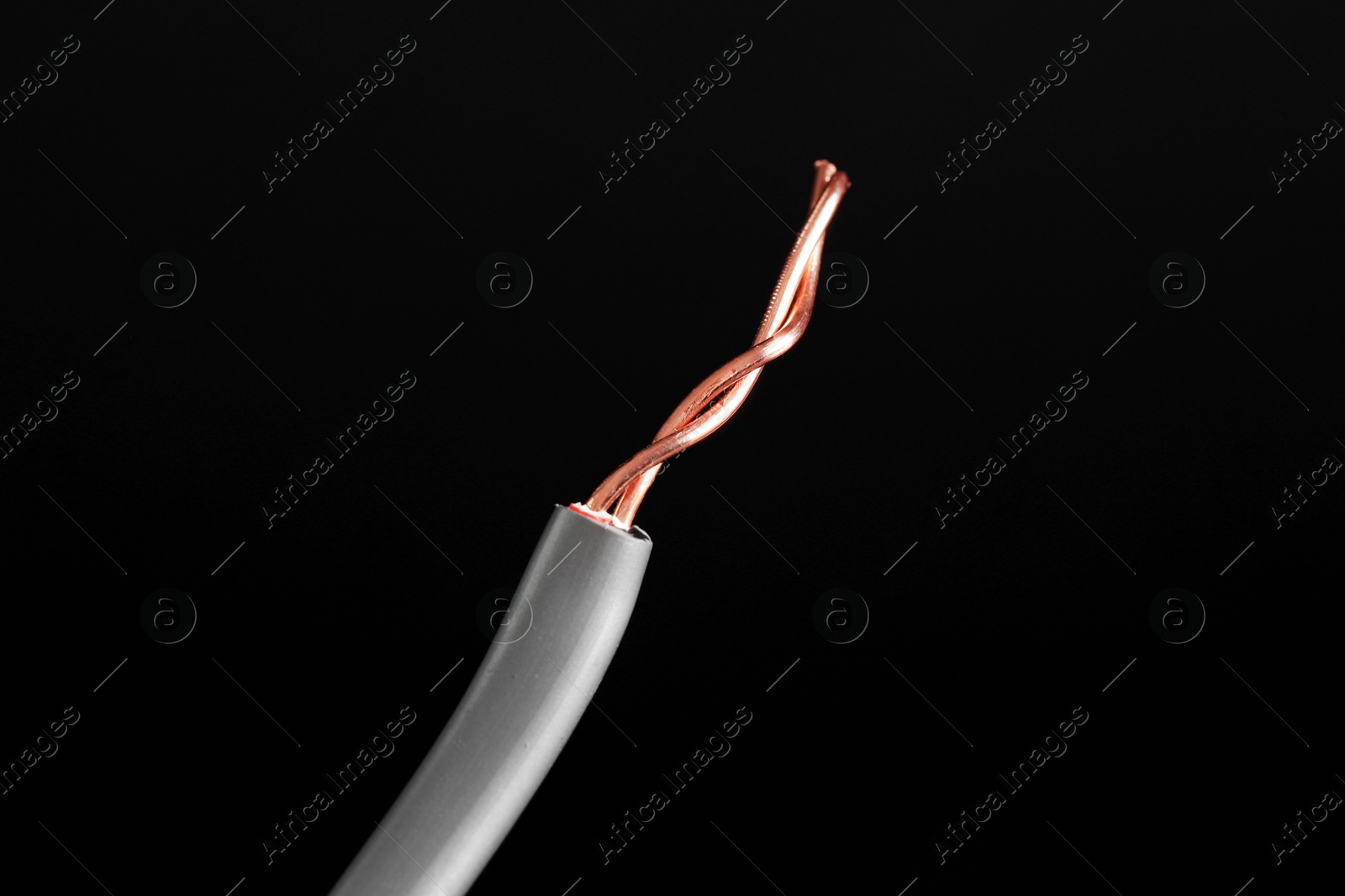 Photo of Grey stripped electrical wire on black background, closeup