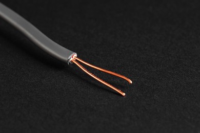 Photo of Grey stripped electrical wire on black background, closeup