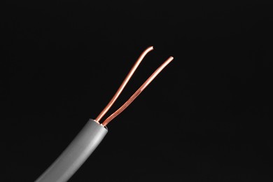 Photo of Grey stripped electrical wire on black background, closeup