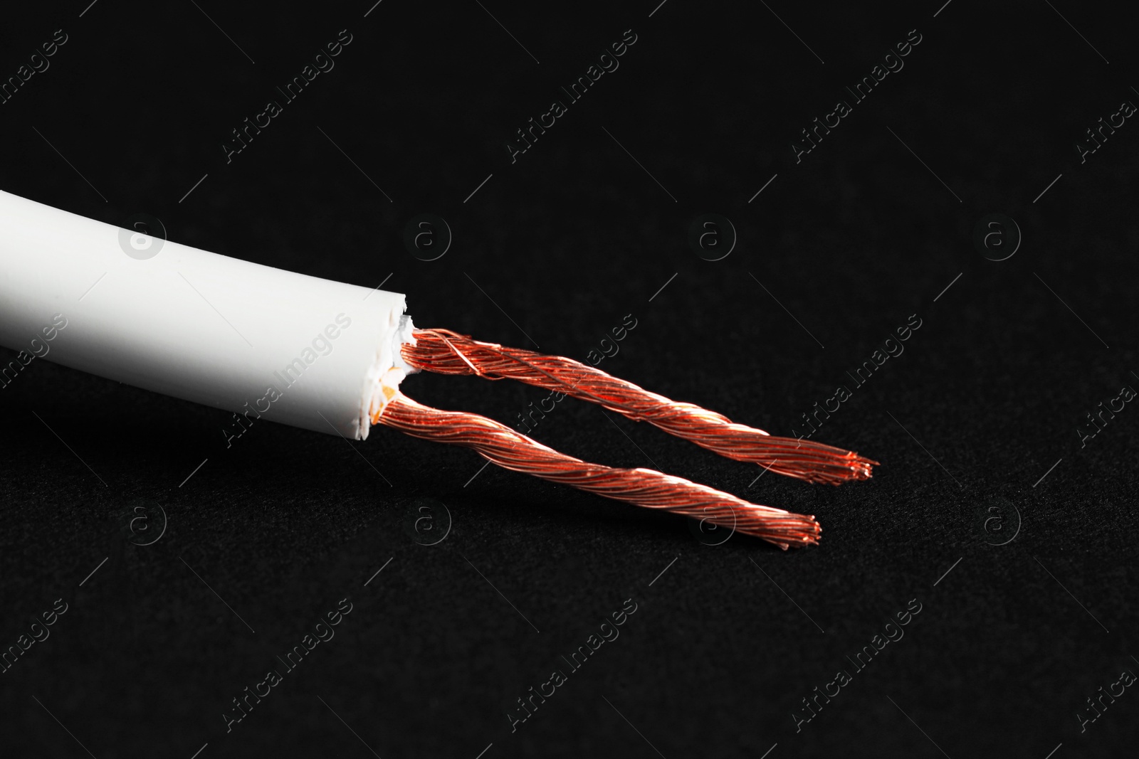 Photo of White stripped electrical wire on black background, closeup