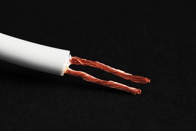 Photo of White stripped electrical wire on black background, closeup