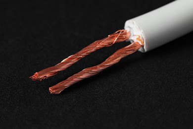 Photo of White stripped electrical wire on black background, closeup