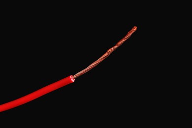 Photo of Red stripped electrical wire on black background, closeup