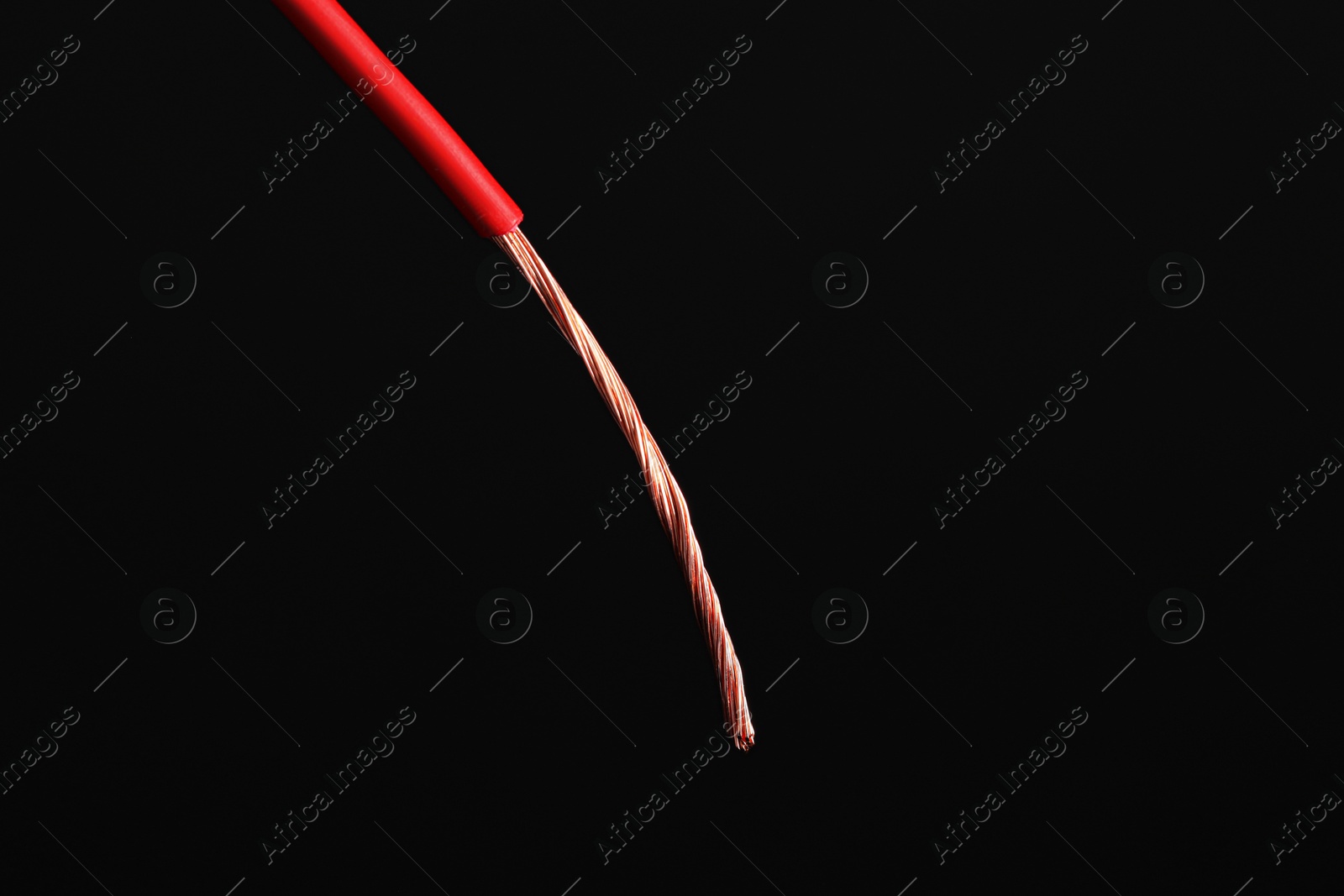 Photo of Red stripped electrical wire on black background, closeup