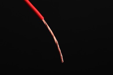 Photo of Red stripped electrical wire on black background, closeup