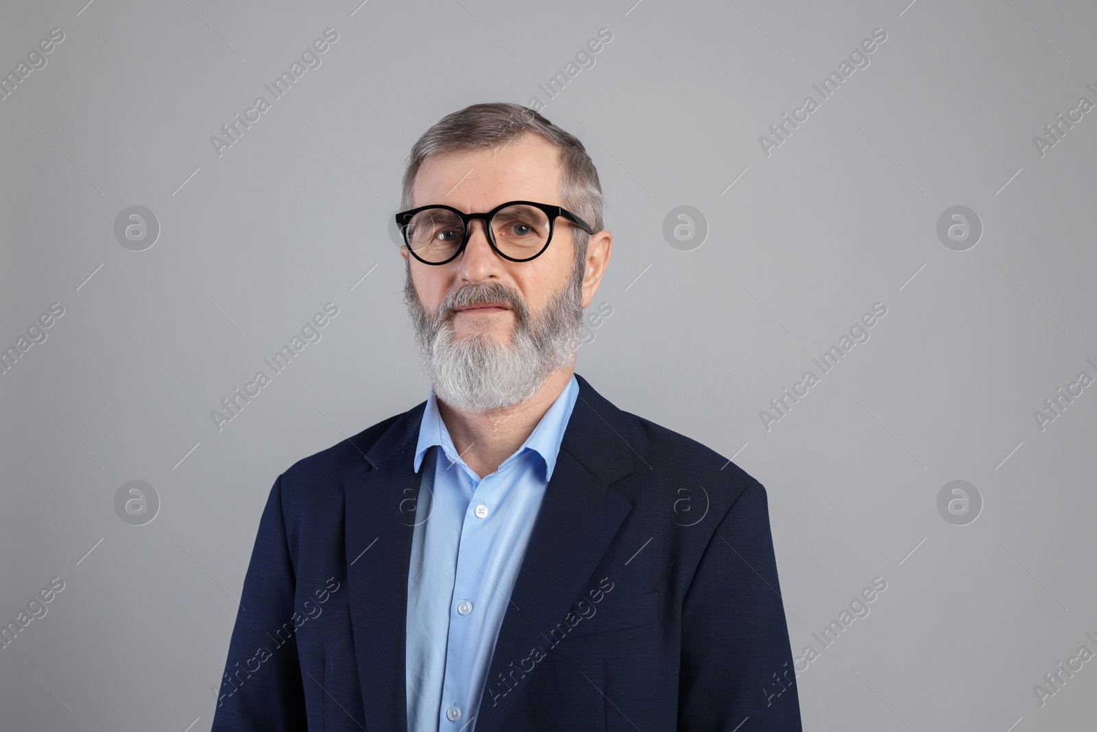 Photo of Portrait of mature man in glasses on grey background