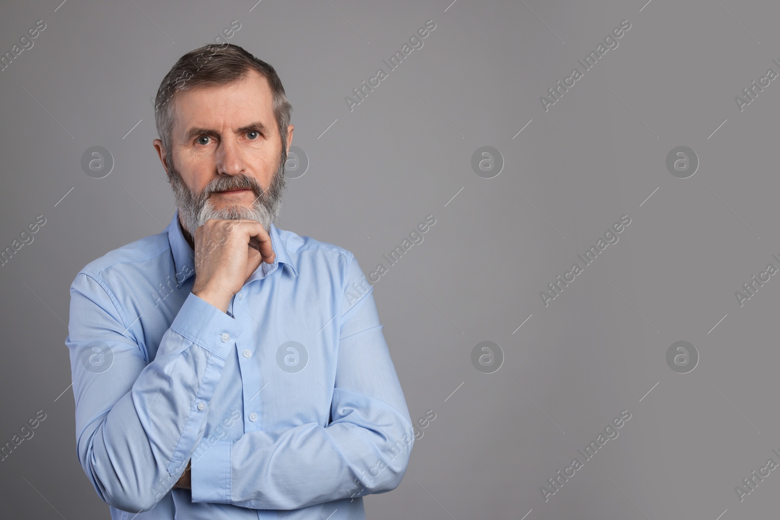 Photo of Portrait of mature man on grey background, space for text