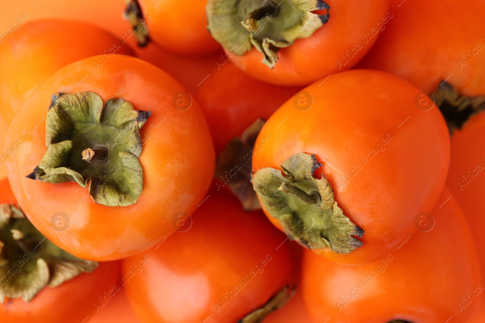 Photo of Delicious fresh juicy persimmons as background, closeup