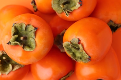 Photo of Delicious fresh juicy persimmons as background, closeup