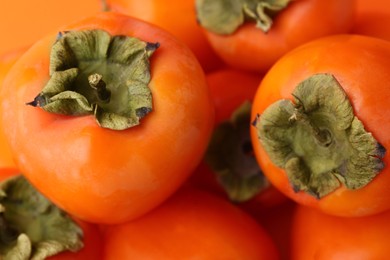 Photo of Delicious fresh juicy persimmons as background, closeup