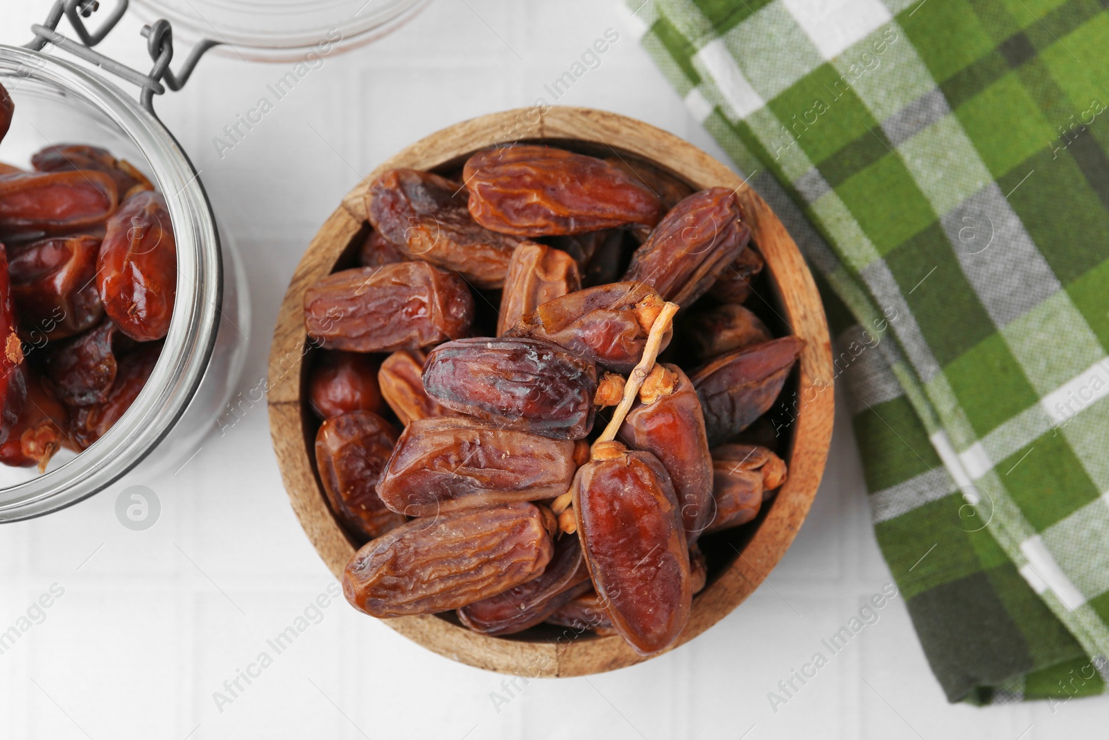 Photo of Tasty dried dates on white tiled table, top view