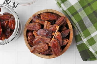 Photo of Tasty dried dates on white tiled table, top view