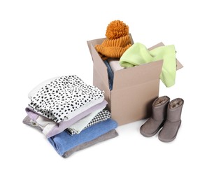 Photo of Box with different used clothes and boots isolated on white