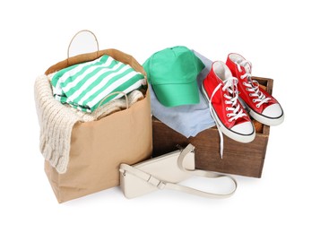 Photo of Packed used clothes, bag and shoes isolated on white