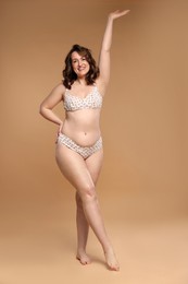 Photo of Beautiful woman in underwear on dark beige background. Cellulite problem