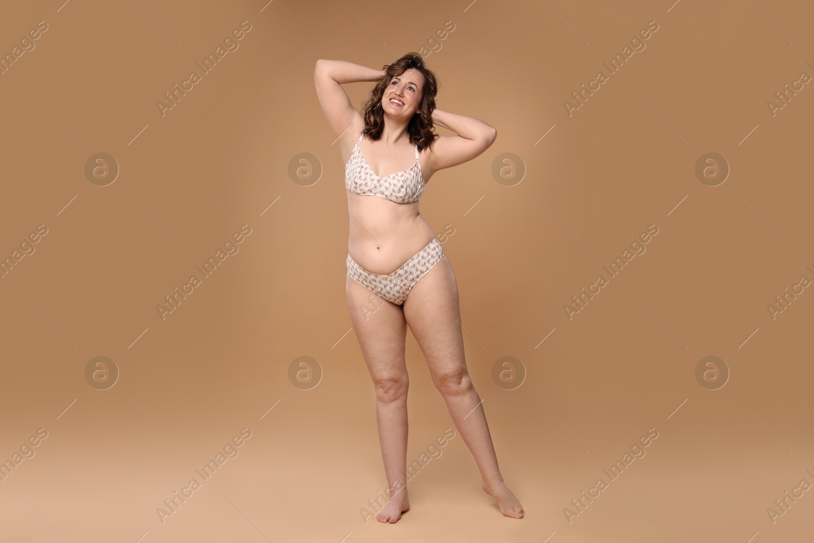 Photo of Beautiful woman in underwear on dark beige background. Cellulite problem