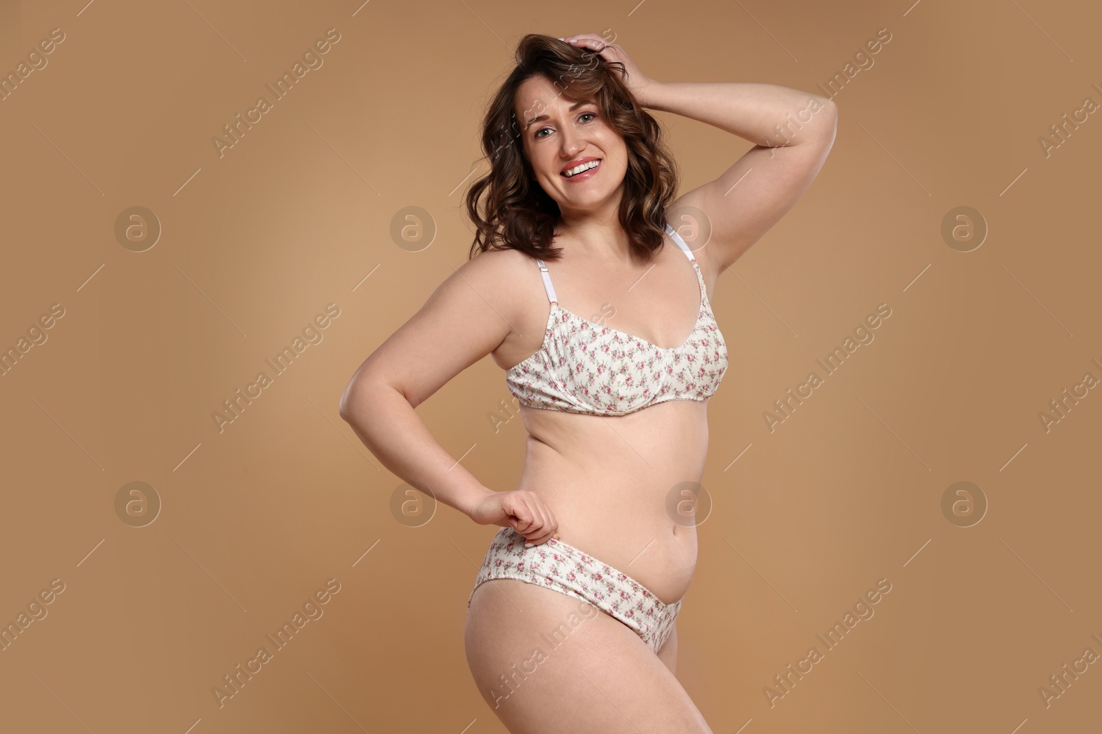 Photo of Beautiful woman in underwear on dark beige background. Cellulite problem