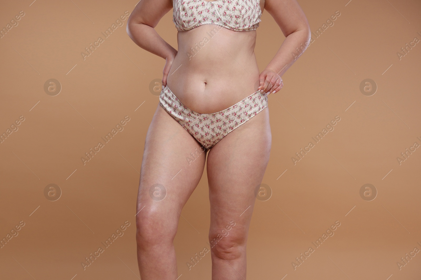 Photo of Woman with cellulite on dark beige background, closeup