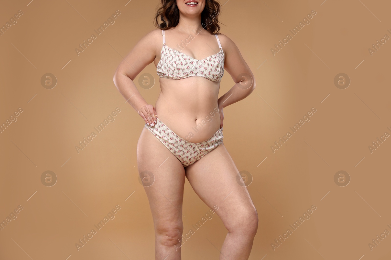 Photo of Woman with cellulite on dark beige background, closeup