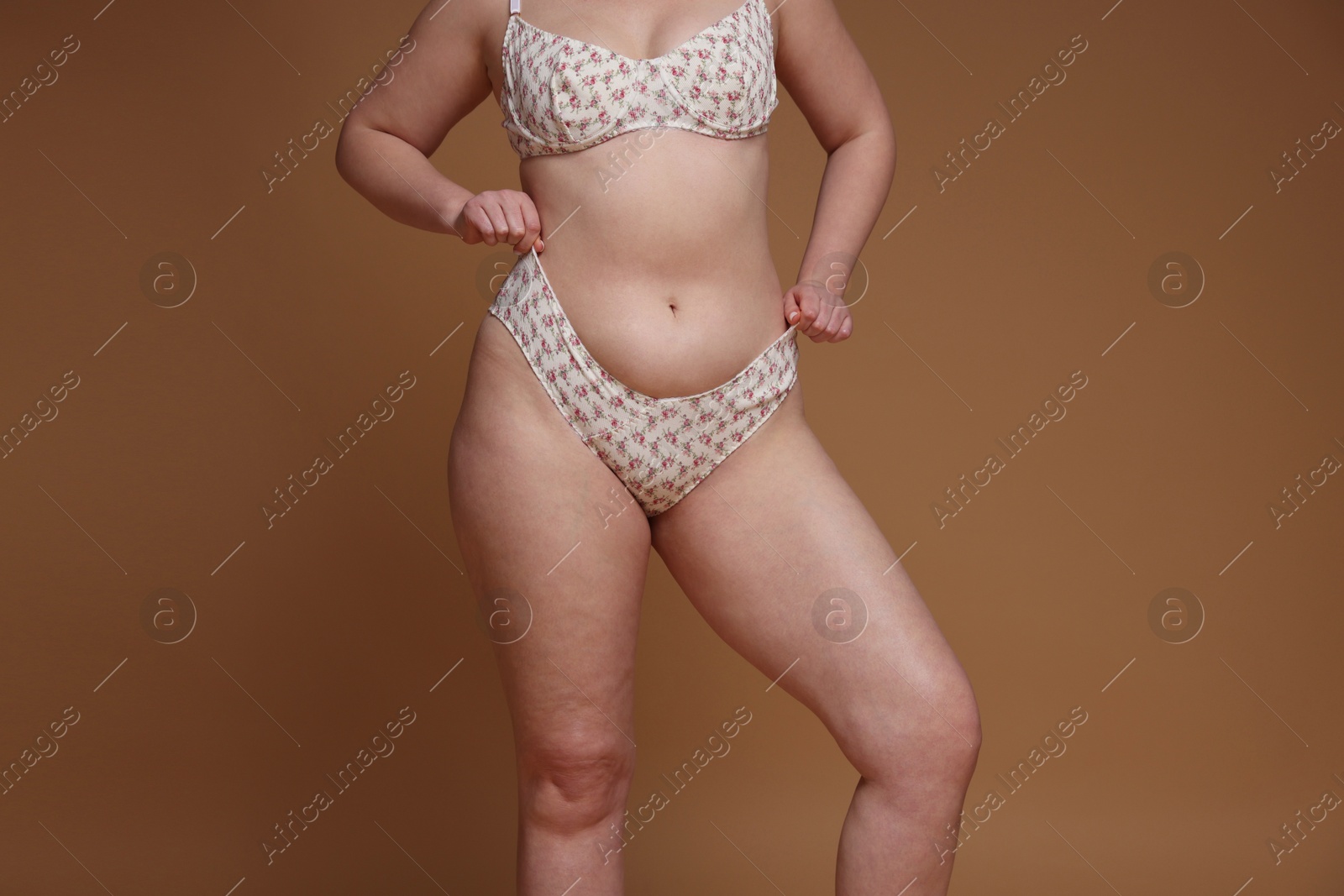 Photo of Woman with cellulite on dark beige background, closeup