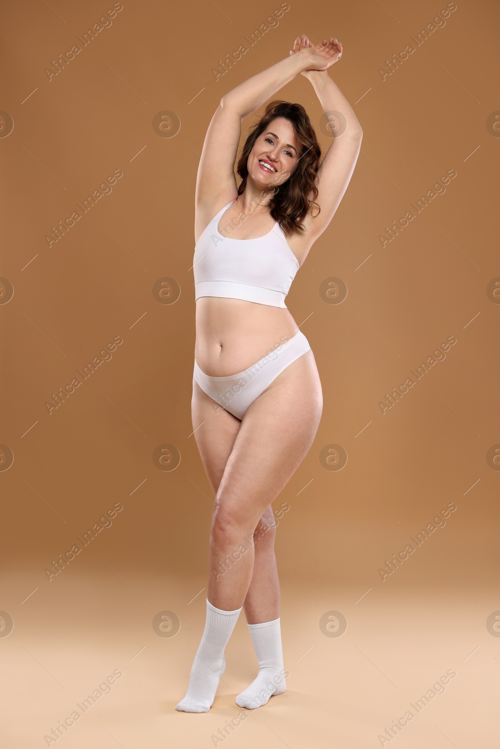 Photo of Beautiful woman in underwear on dark beige background. Cellulite problem