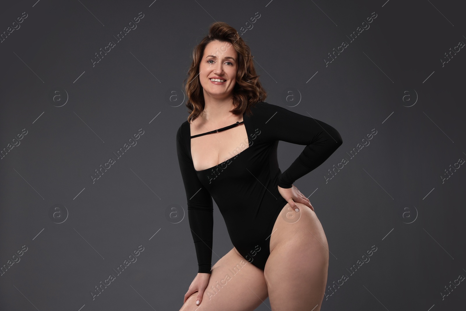 Photo of Beautiful woman in bodysuit on dark grey background. Cellulite problem