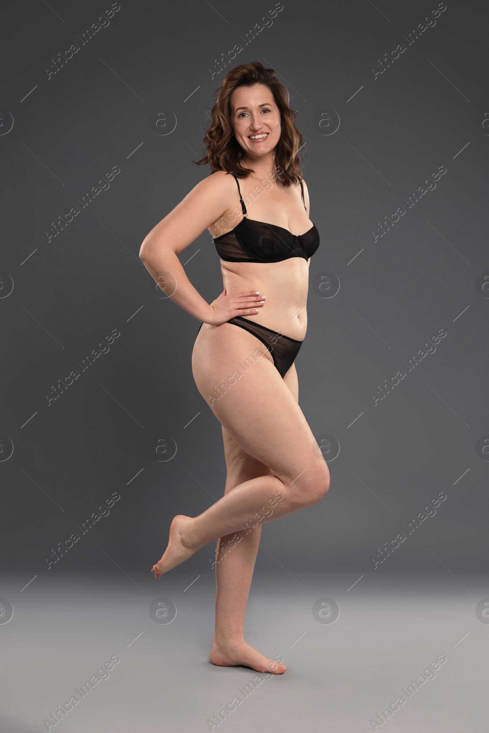 Photo of Beautiful woman in underwear on dark grey background. Cellulite problem