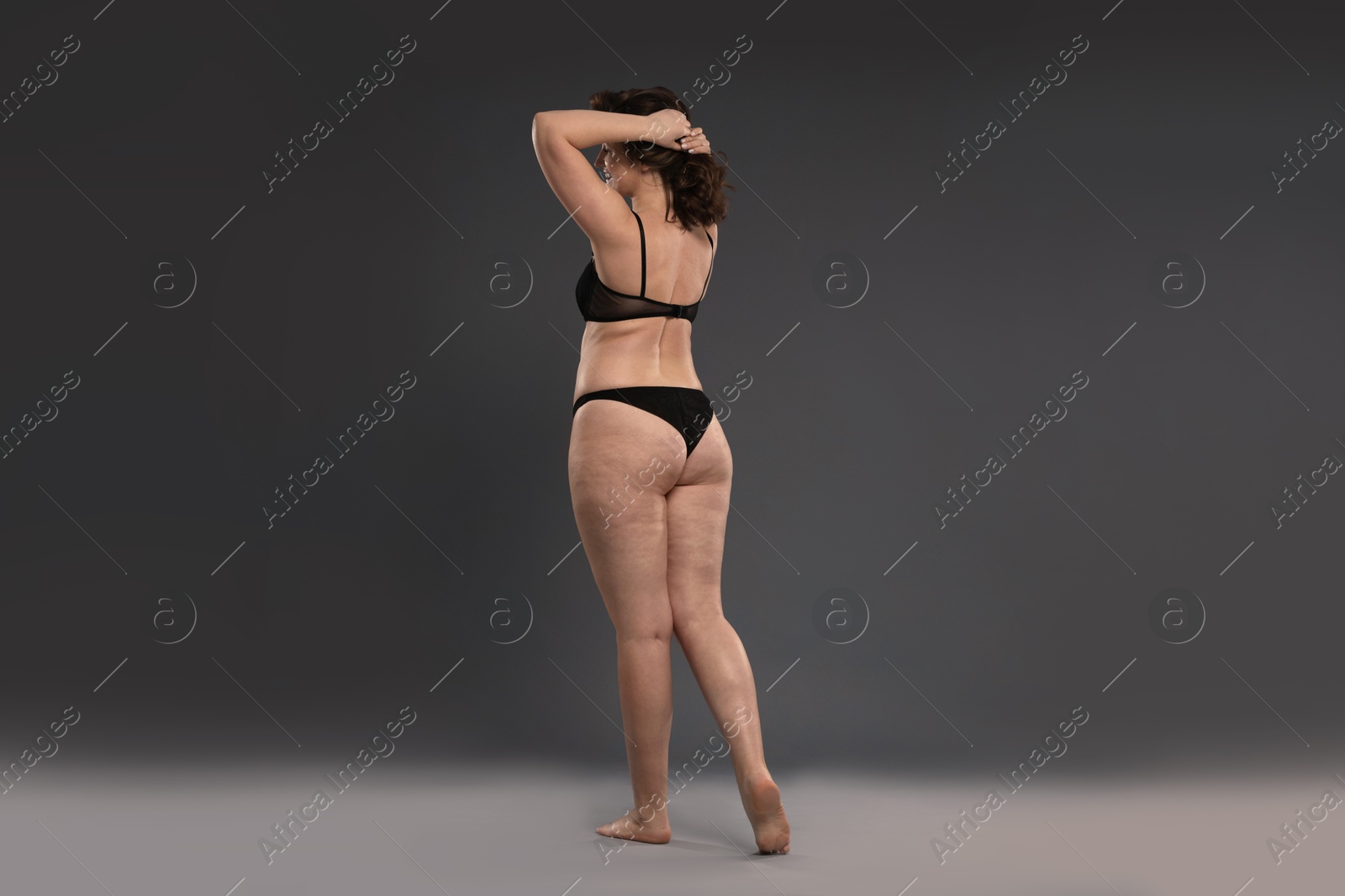 Photo of Beautiful woman in underwear on dark grey background. Cellulite problem