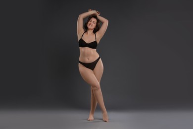 Photo of Beautiful woman in underwear on dark grey background. Cellulite problem