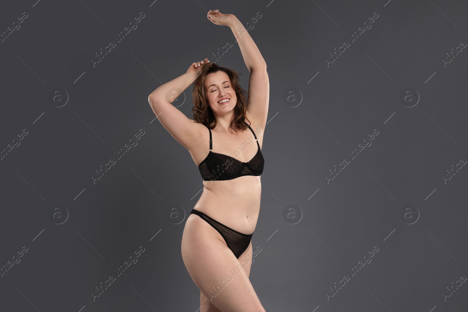 Photo of Beautiful woman in underwear on dark grey background. Cellulite problem