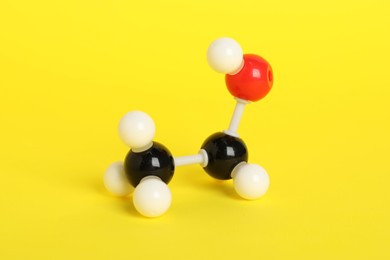 Photo of Molecule of ethanol on yellow background. Chemical model