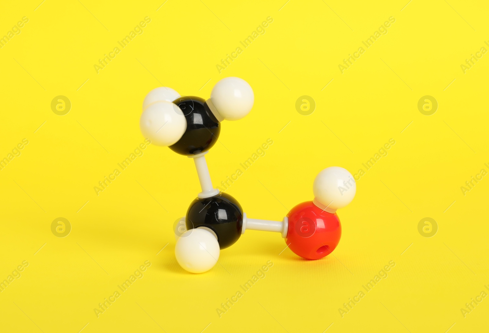 Photo of Molecule of ethanol on yellow background. Chemical model