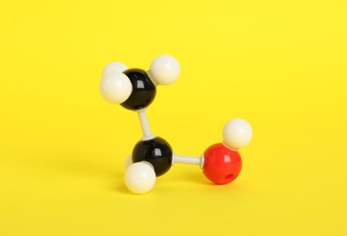 Photo of Molecule of ethanol on yellow background. Chemical model