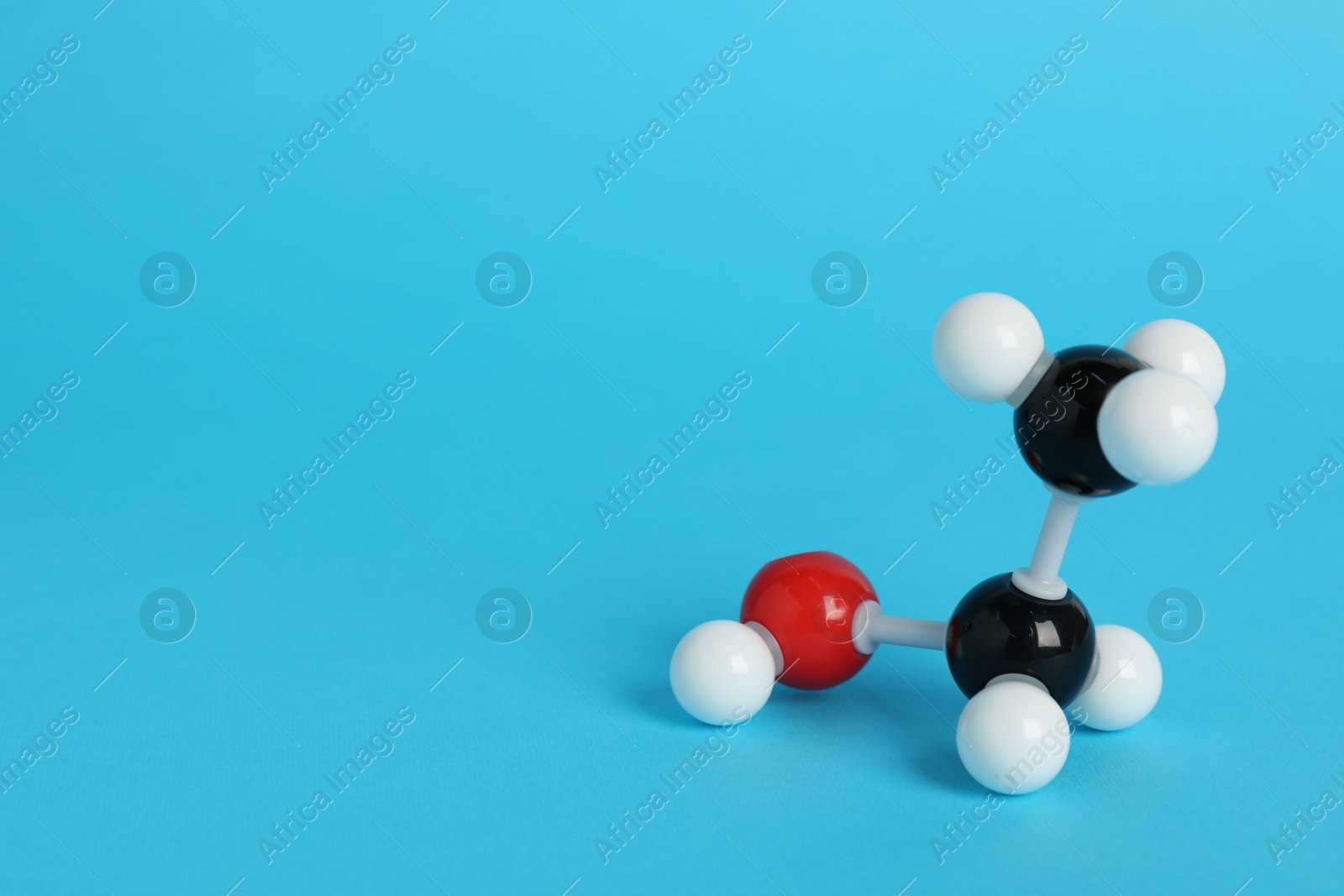 Photo of Molecule of ethanol on light blue background, space for text. Chemical model