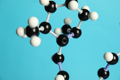 Photo of Molecule of retinol (vitamin A) on light blue background, closeup. Chemical model